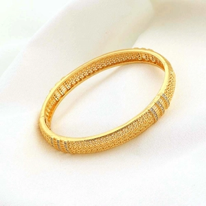 Dettaglio di un bracciale placcato oro 18k con motivi floreali traforati e zirconi