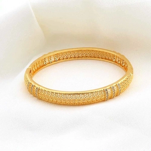 Dettaglio macro del bracciale placcato oro 18k con motivi floreali traforati e zirconi