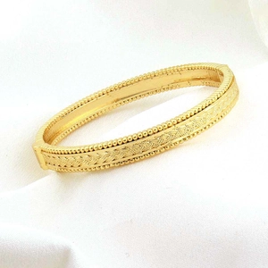 Dettaglio del bracciale placcato oro 24k con trama intrecciata e bordi decorati