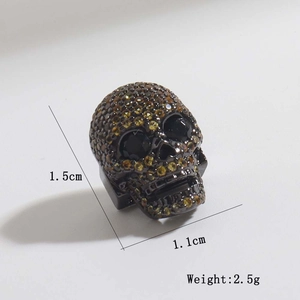 Dettaglio charm teschio canna di fucile con zirconi gialli, misura 1,5 cm x 1,1 cm e 2,5 g