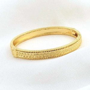 Dettaglio di un bracciale placcato oro 24k con trama vintage e chiusura sicura