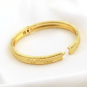Dettaglio del bracciale intrecciato placcato oro 24k con chiusura vintage su tessuto