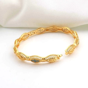 Detail van een 18k vergulde armband met blauwe zirkonia en holle bloempatronen