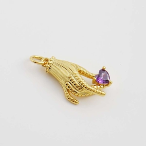 Pendentif griffe d'oiseau dorée tenant un cristal coeur violet sur fond blanc