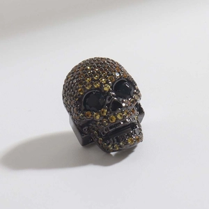 Ciondolo teschio in metallo nero con pavé di zirconi marroni e occhi in pietre nere