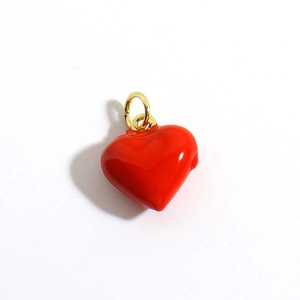 Dettaglio ravvicinato di un ciondolo a cuore in smalto rosso con anello a scatto dorato lucido