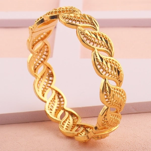 Detail van 18k vergulde armband met fijne opengewerkte bladpatronen en matte texturen