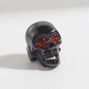 Dettaglio dell'anello teschio gotico in metallo nero con occhi in zircone cubico rosso