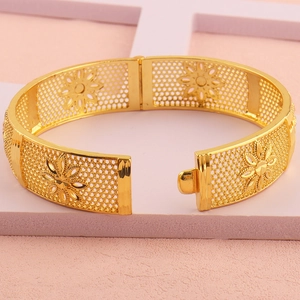Detailopname van de 18k vergulde opengewerkte armband met verfijnd bloemenpatroon