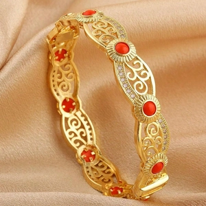 Detail of 18K gold-plated cuff featuring hollow vintage patterns and red stones