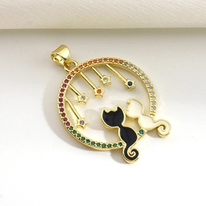 Close-up of gold-plated pendant with black and white cats and colorful zircon stones