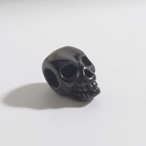 Dettaglio di un ciondolo a teschio nero con zirconi per la creazione di gioielli DIY