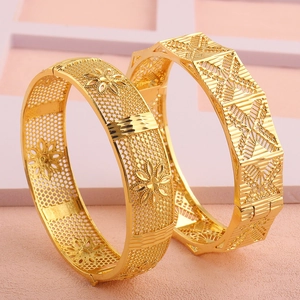 Detail van 18k vergulde armbanden met ingewikkelde holle bloemen en geometrische patronen