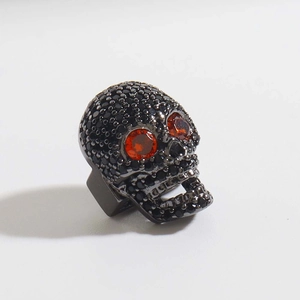 Vista macro dello charm a teschio con zirconi neri micro-incastonati e occhi arancioni