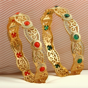 Macro shot of 18K gold plated hollow cuff bracelets with red green gems and zircon