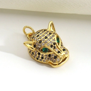 Macro detail of gold-plated leopard head pendant with micro-paved zircons and emerald eyes