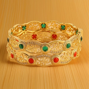 Hollow gold-plated bangle with ethnic filigree design and red green gemstones