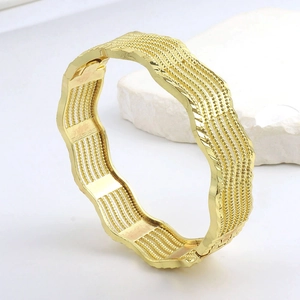 Lussuoso bracciale a polsino dorato ondulato con texture a perline e strisce lucide