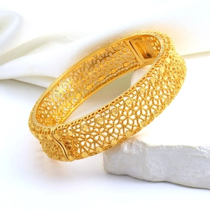 Dettaglio del bracciale rigido placcato oro 24K con intricati intagli floreali traforati