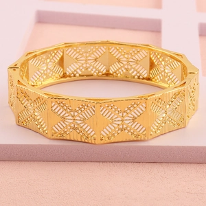 Detail van 18k vergulde armband met holle geometrische patronen op een brede manchet