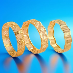 Detailweergave van drie 18k vergulde armbanden met gravures en geometrische patronen