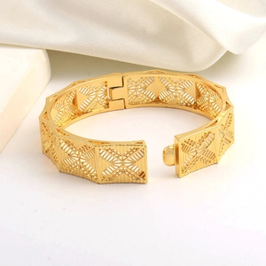 Vista macro dettagliata del bracciale largo placcato oro 24K con motivo a X cavo