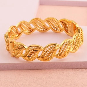 Macro-opname van een 18k vergulde brede armband met ingewikkelde bloemengravures