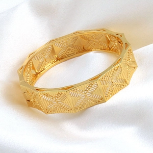 Lussuoso bracciale rigido largo placcato oro 24K con intricati intagli geometrici