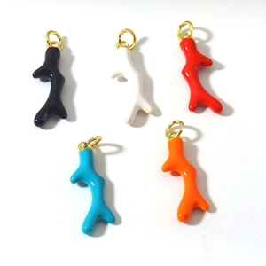 Détail macro de pendentifs corail colorés avec boucles métalliques dorées polies