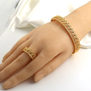 Detail of luxury gold-plated bangle and ring set with black and white marquise stones