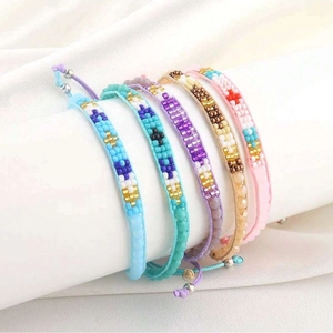 Détail de cinq bracelets en perles faits main avec cordons tressés et nœuds réglables