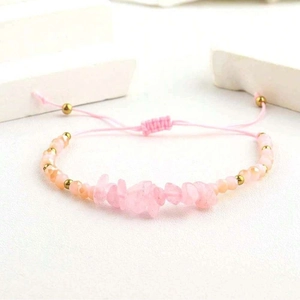 Détail des perles en pierre rose et du cordon tressé réglable sur le bracelet