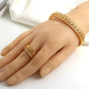 Close-up of gold plated ring and open bangle set with white and turquoise cubic zirconia