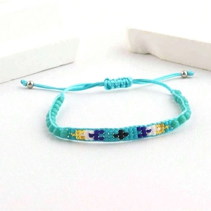 Détail d'un bracelet tissé turquoise avec des perles colorées et un cordon ajustable