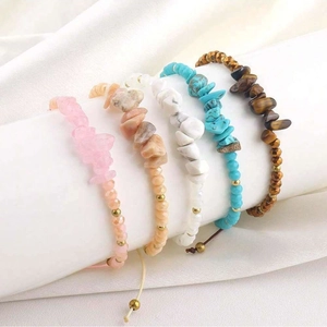 Détail de cinq bracelets en perles de pierre naturelle faits main sur un présentoir