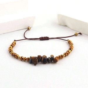 Détail du bracelet tissé à la main avec pierres œil de tigre et perles dorées