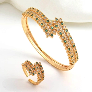 Detailed macro view of gold-plated jewelry set with double-row green and white zircons