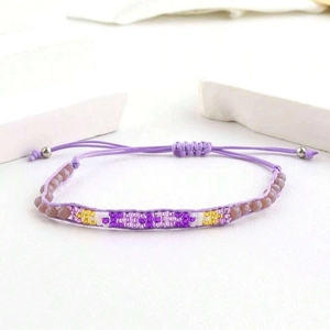 Détail du bracelet tissé main violet avec cordon de serrage réglable et perles rondes