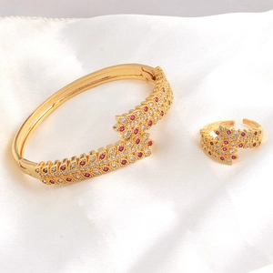 Detail of gold-plated bangle and ring set with red and white pavé cubic zirconia