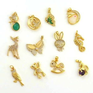 Macro view of twelve assorted gold plated zircon animal pendants for DIY jewelry making