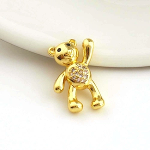 Close-up of golden bear pendant with heart-shaped white zircon inlay and fine metal craftsmanship