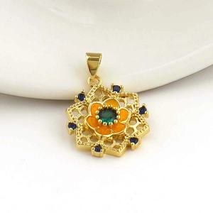 Macro detail of 18k gold plated flower pendant with green stone and orange enamel petals