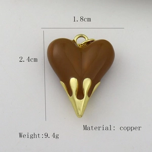 Detail view of a 1.8cm brown enamel heart pendant with gold fluid drip design in copper