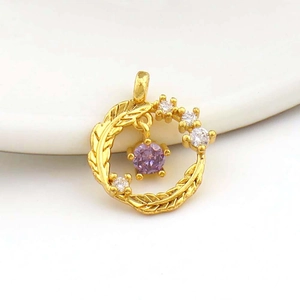 Detailed macro of a 18k gold plated windmill floral pendant with purple zircon crystal