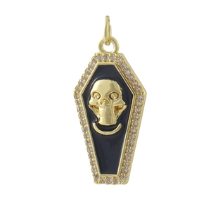 Macro detail of gothic coffin pendant with gold skull, black enamel and cubic zirconia