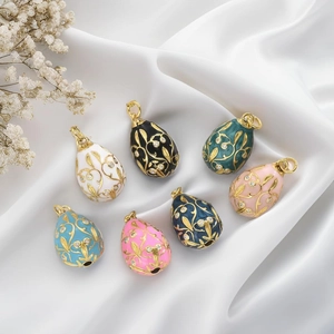 Detailed view of colorful Fabergé-style enamel egg pendants with golden filigree and crystals