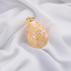 Detail of pink enamel Faberge-style egg pendant with gold filigree and sparkling crystals