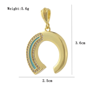 Macro shot of 18k gold plated horseshoe pendant with blue enamel and white zirconias
