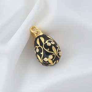 Detail of egg pendant with black enamel gold filigree and inlaid zircon on silk