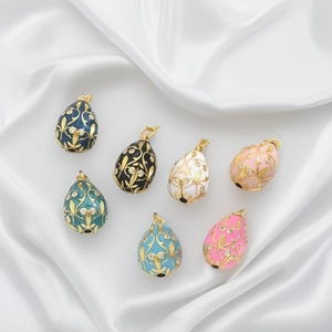 Macro shot of colorful Faberge-style egg pendants with gold patterns and small rhinestones